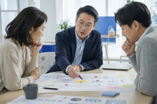 업무 흐름도를 펼쳐 놓고 해결해야 할 문제가 무엇인지 먼저 분석하는 모습