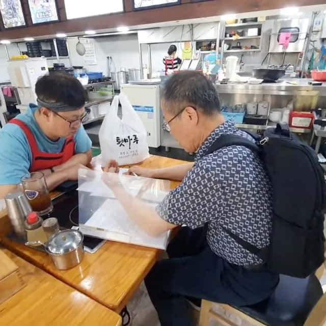 식당 주방 옆 테이블에서 사장님과 함께 서류를 보며 진행하는 현장 컨설팅