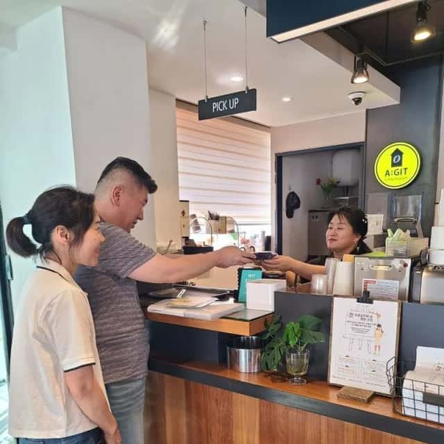 카페 카운터에서 사장님과 대화하며 진행하는 현장 방문 컨설팅