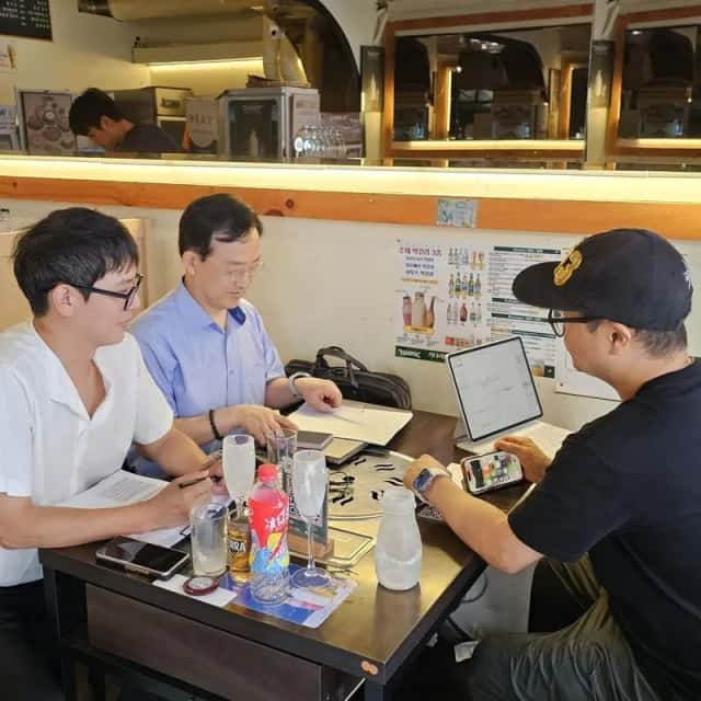소상공인 매장 테이블에서 사장님과 함께 노트북 화면을 보며 진행하는 현장 컨설팅