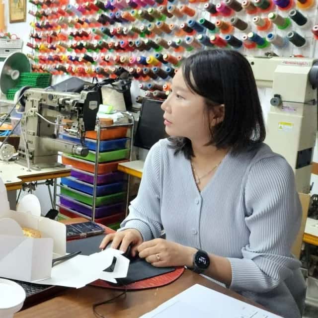 봉제 작업장에서 소상공인과 마주 앉아 상담하는 컨설턴트