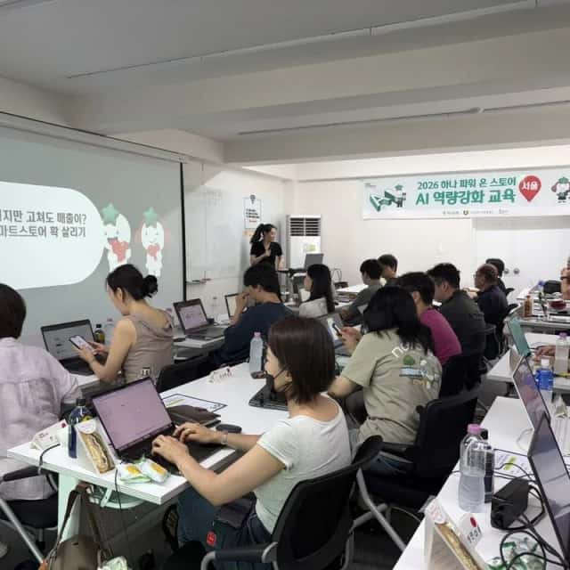 AI 역량강화 교육 현수막 아래 노트북으로 실습하는 소상공인 수강생들