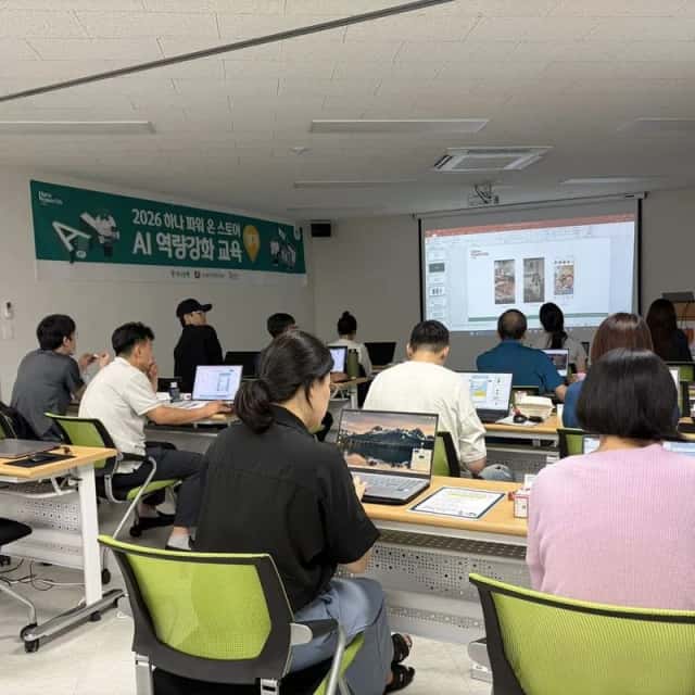 강사가 화면 앞에서 설명하고 수강생들이 노트북으로 따라 하는 교육 장면