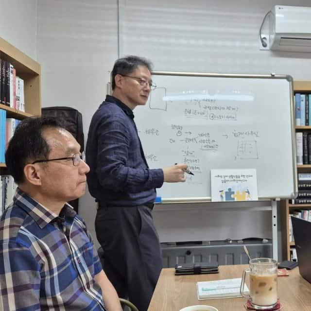 화이트보드에 업무 흐름을 그려가며 기업 담당자와 논의하는 장면
